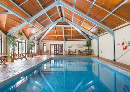 普里茅斯Bovisand Lodge Holiday Park的一座带木制天花板的别墅内的游泳池