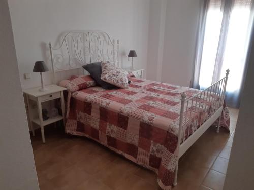 丰特埃里多斯Alojamiento La Fuente的一间卧室配有一张带红白毯子的床