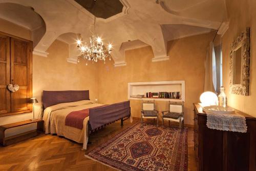 多利亚尼Antico Hospitale的一间卧室配有一张床和一个吊灯