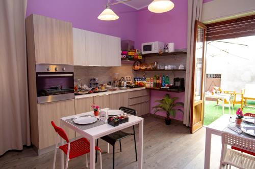 尼科洛西菲奥里迪拉瓦住宿加早餐旅馆的厨房设有紫色墙壁和桌椅