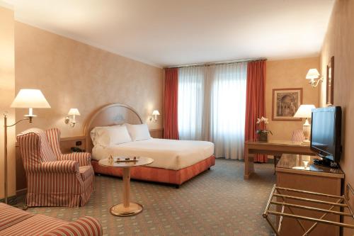 比耶拉阿戈拉皇宫酒店的酒店客房,配有床和电视