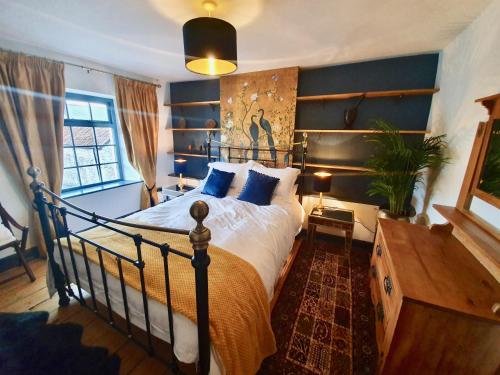 弗罗姆Fern Tree Cottage的一间卧室配有一张带蓝色墙壁的大床