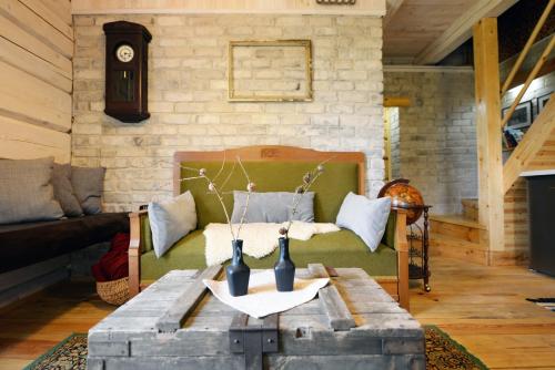 杜宾吉亚克流凯乡村民宿的客厅配有沙发和一张带花瓶的桌子
