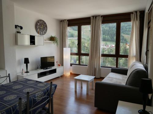 埃尔塔特El Tarter-Vacances Pirinenca的带沙发和大窗户的客厅