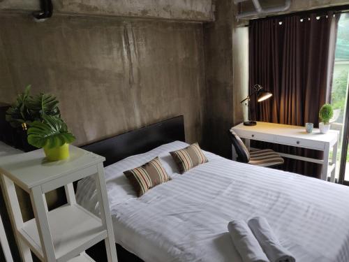 Bangkok YaiTHE HOG的卧室配有白色的床、书桌和窗户。