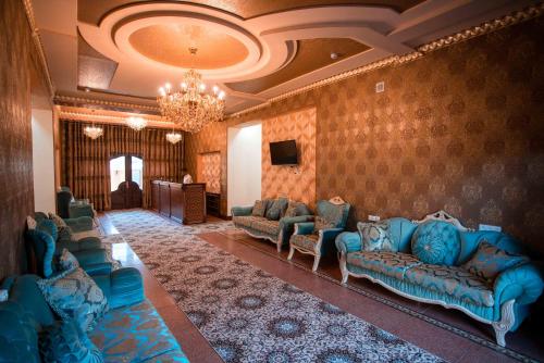 布哈拉Caravan Castle Boutique Hotel的客厅配有蓝色的沙发和电视