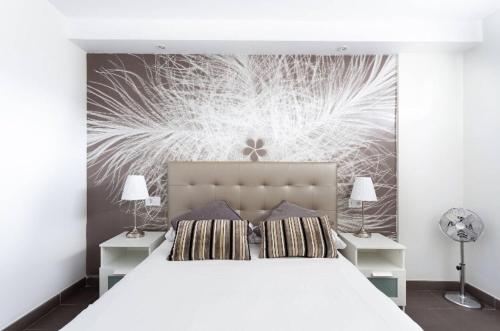 洛斯克里斯蒂亚诺斯Vacation Home 1 Bed Los Cristianos的一间卧室配有一张带两盏灯的大型白色床。