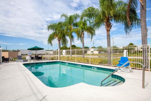 维洛海滩维洛海滩豪生国际快捷酒店的一个带蓝椅和棕榈树的游泳池