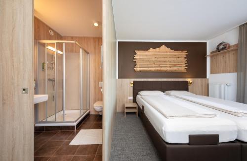 霍赫菲尔岑Fairhotel Hochfilzen B&B的一间卧室设有一张大床和淋浴