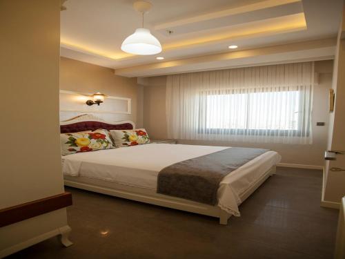 艾登Lion Park Suites & Residence Hotel的一间卧室设有一张大床和窗户