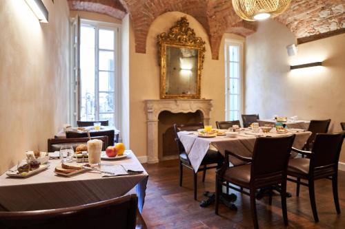 布雷西亚Locanda delle Mercanzie的一间带桌椅和壁炉的用餐室