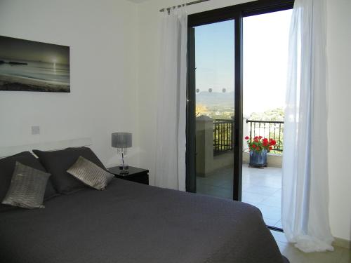 尼奥克瑞奥Villamia的一间卧室设有一张床,享有阳台的景色