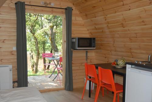 RiansLe Pod de L'Adret的小木屋内的厨房配有桌椅