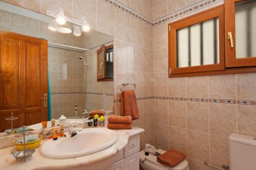 蒂亚斯Villa Juanita, Puerto del Carmen, Lanzarote的一间带水槽、卫生间和镜子的浴室