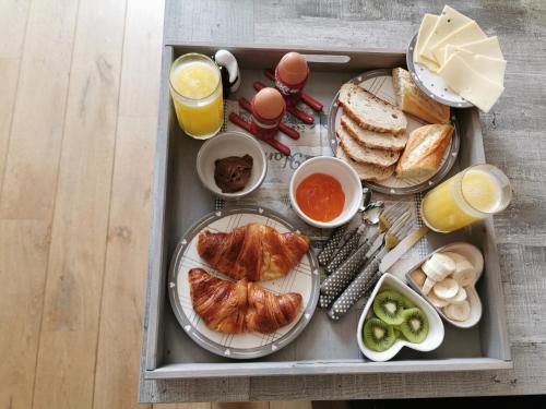 绍蒙－吉斯图LA RIVIERE DU BIEN ETRE的包括鸡蛋、面包和橙汁的早餐托盘