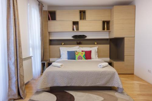 克卢日-纳波卡Presecan One Room Apartment with view的卧室配有一张带彩色枕头的大型白色床。