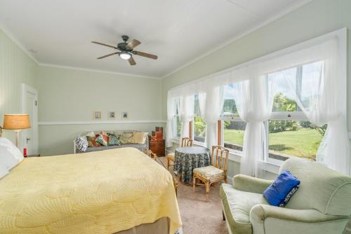 希洛Old Hawaiian Bed and Breakfast的一间卧室配有一张床、一张沙发和一个窗口