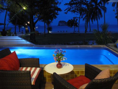 奈岛许海梦幻温泉度假酒店的一个带椅子和一张花瓶桌子的游泳池