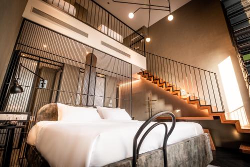 吉隆坡吉隆坡MOV酒店的一间带大床和楼梯的卧室