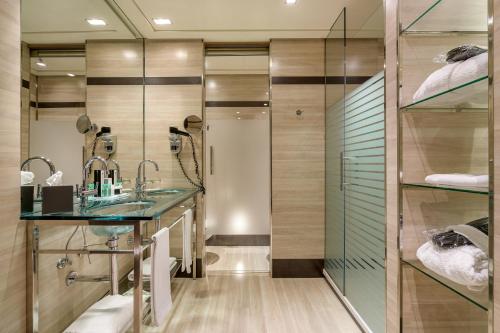 马德里Hotel Maydrit Airport的一间带玻璃淋浴和水槽的浴室