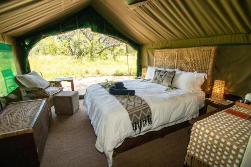 SihangwaneTembe Elephant Park Lodge的帐篷内一间卧室,配有一张床