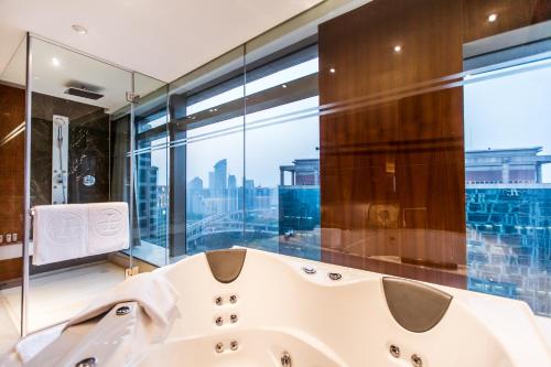 上海新天地朗廷酒店 的一间带白色浴缸和大窗户的浴室