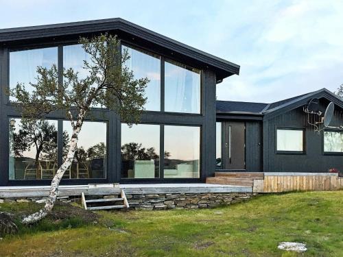 莱帕乔德6 person holiday home in Kvalsund的一间黑色的房子,设有大窗户和一棵树