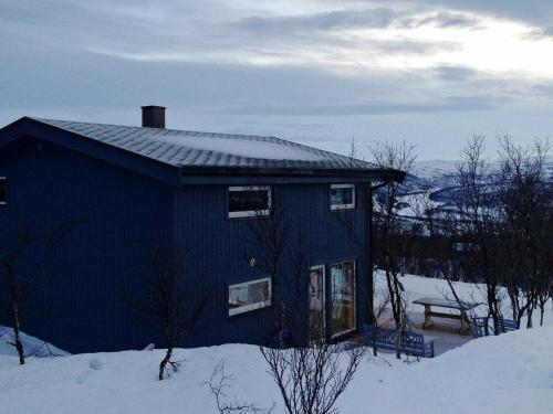 莱帕乔德6 person holiday home in Kvalsund的雪中带长凳的蓝色房子