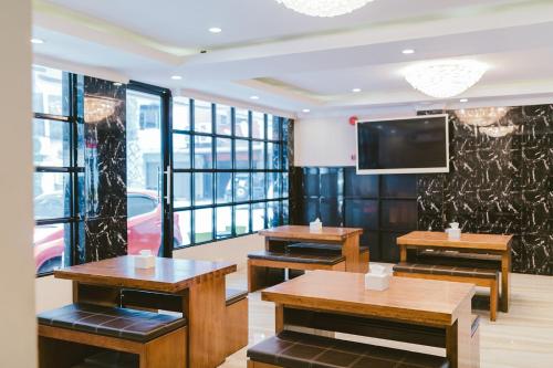 名古屋Barelang Hotel Nagoya Batam的餐厅设有2张桌子和平面电视