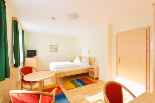 莱奥本Hotel Kindler 2,0 Self-Check-In的配有一张床和一张桌子及椅子的房间