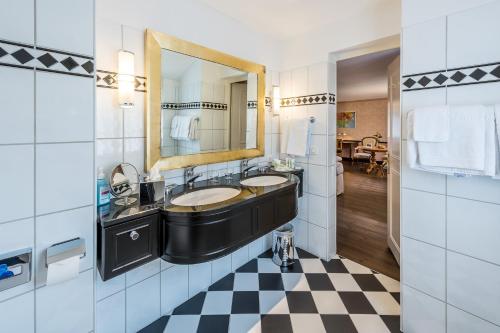 申纳克巴德克尔公园酒店的浴室设有2个水槽和镜子,铺有 ⁇ 格地板。