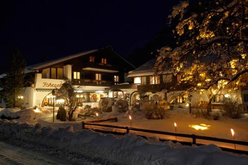 法尔先特福赫霍夫嘉妮酒店的一座晚上在雪中点亮的建筑