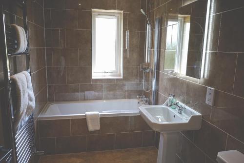 康达格林穆勒康德格林酒店的带浴缸和盥洗盆的浴室
