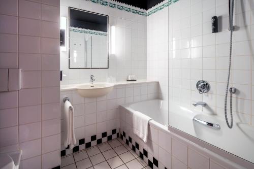 宰斯特菲基剧院酒店的白色的浴室设有浴缸和水槽。