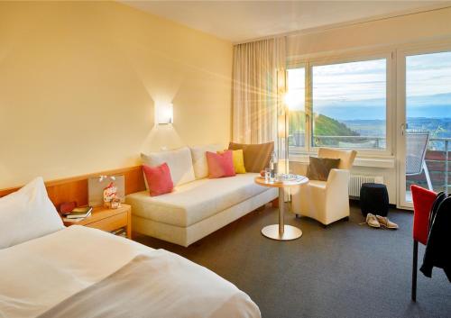 洛伊费尔芬根拉姆萨奇巴德酒店的酒店客房设有床、沙发和窗户。