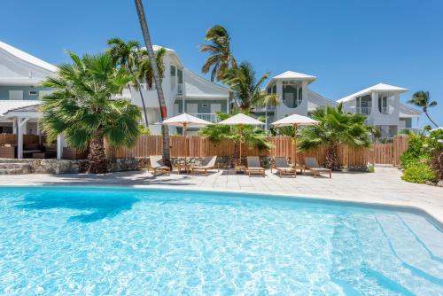 东方湾拉普拉亚东方湾酒店的度假村的游泳池配有椅子和遮阳伞