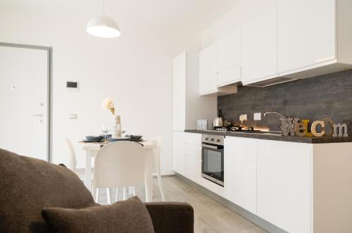 菲乌米奇诺FCO Luxury Apartments的一间厨房,内设白色橱柜和一张桌子