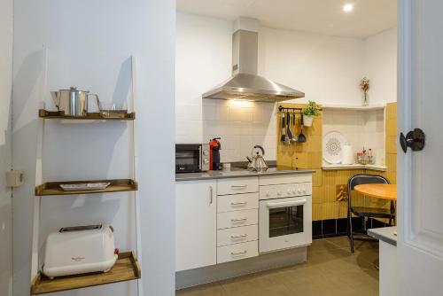 赫罗纳APG Espais Rambla的厨房配有白色橱柜和炉灶烤箱。