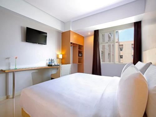 德波德波珊迪卡酒店的酒店客房设有白色的床和窗户。