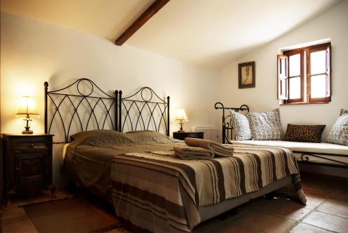 埃尔乔罗Cortijo Don Camilo de La HUMA的一间卧室配有一张大床和一张沙发