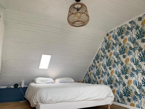 伊勒蒂迪Jolie maison au port de l’Ile Tudy的一间卧室配有一张蓝色和白色墙壁的床