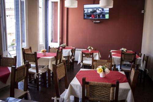 康考迪亚Hotel Federico I的餐厅设有桌椅和红色的墙壁