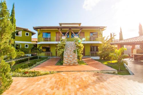 塞古罗港Vila Miola Hotel的黄色的房子,前面有楼梯