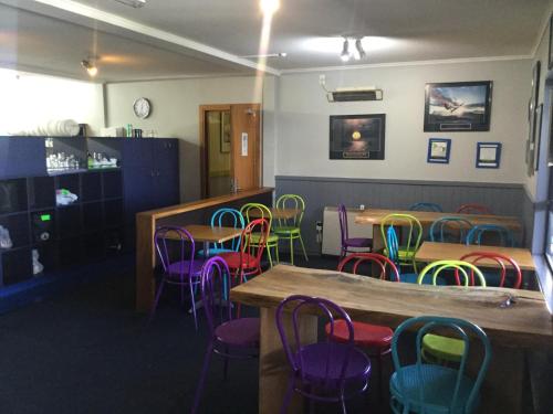 福克斯冰川Ivorytowers Accommodation的用餐室配有桌子和五颜六色的椅子