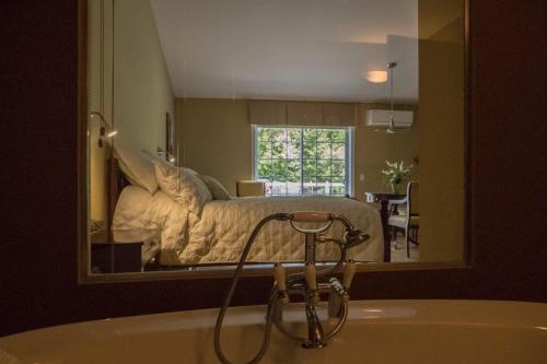 PiedmontStudio-hôtel Villegiature Saint-Sauveur的卧室内的浴室镜子和床