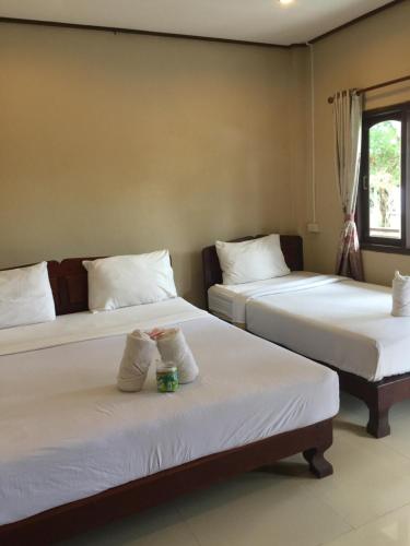 东德岛肯萨瓦特乐比久旅馆的两张睡床彼此相邻,位于一个房间里