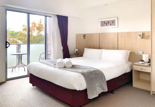 布里斯班阿斯科特机场汽车旅馆的酒店客房设有一张大床和一个阳台。