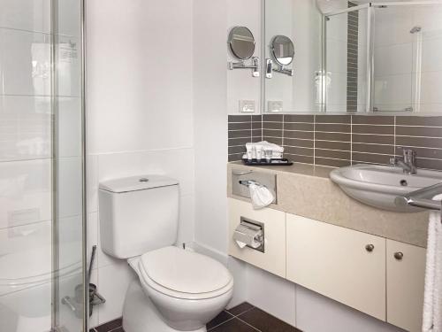 布里斯班阿斯科特机场汽车旅馆的白色的浴室设有卫生间和水槽。
