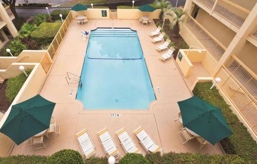 盖恩斯维尔Days Inn by Wyndham Gainesville Florida的享有带遮阳伞的游泳池的顶部景致