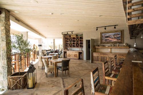佩尼契Surfers Lodge Peniche的餐厅设有木制天花板和桌椅